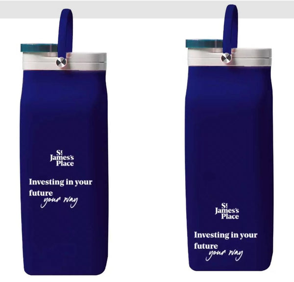 Two navy blue foldable silicone bottles with silver caps and loop handles, printed with a corporate logo and slogan in white.