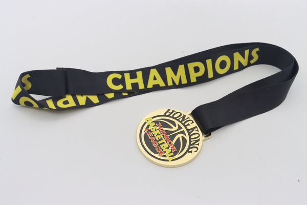 A gold medal with a basketball design on a black ribbon printed with the word Champions in yellow.